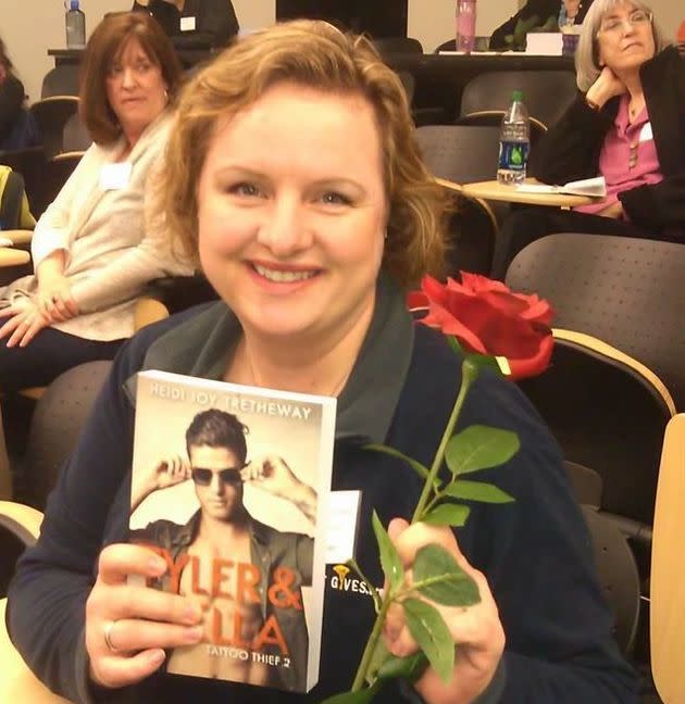 Heidi Joy Tretheway holds a rose she received from Crampton Brophy — who gave them out to authors who finished their books, and who had heavily critiqued its original cover.