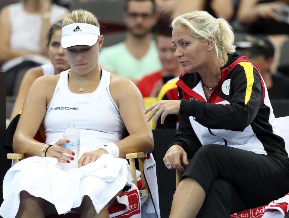 Angelique Kerber of Germany, left, and her team captain Barabara Rittner, right, talk between sets in her match against Samantha Stosur of Australia during the Fed Cup semifinals between Australia and Germany in Brisbane, Australia, Sunday, April 20, 2014. (AP Photo/Tertius Pickard)