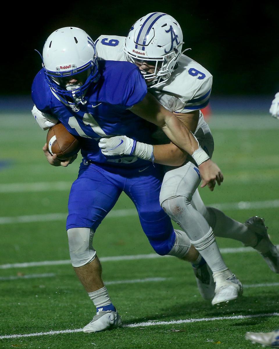 Scituate’s Andrew Bossey is brought down by Ashland’s Matt Gillis from behind during third quarter action of their Round of Eight game against Scituate in the Division 4 state tournament at Scituate High School on Friday, Nov. 12, 2021.