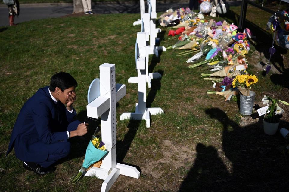 People pay their respects at a makeshift memorial for victims at the Covenant School building at the Covenant Presbyterian Church (AFP via Getty Images)