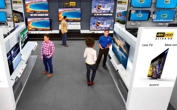 The Samsung section at a Best Buy store with shoppers and a sales rep.