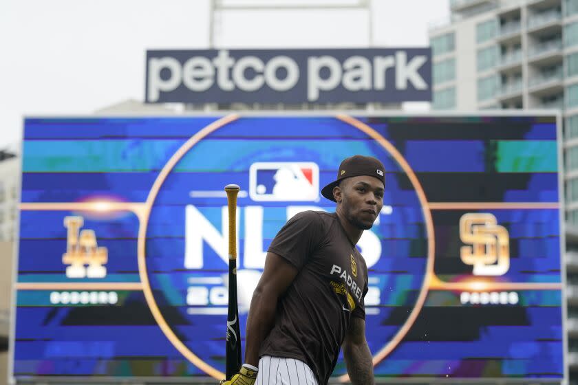 San Diego Padres right fielder Jose Azocar walks in front of the Petco Park sign and scoreboard during a workout