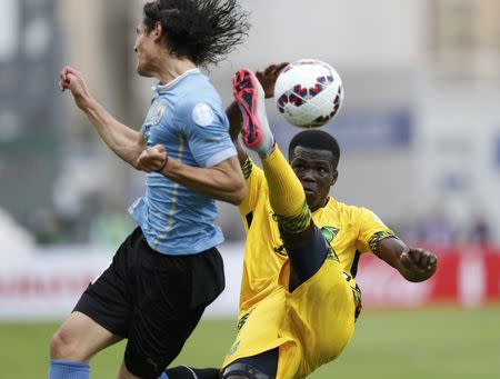 Jamaica's Kemar Lawrence kicks the ball behind Uruguay's Edinson Cavani during their first round Copa America 2015 soccer match at Estadio Regional Calvo y Bascunan in Antofagasta, Chile, June 13, 2015. REUTERS/Andres Stapff