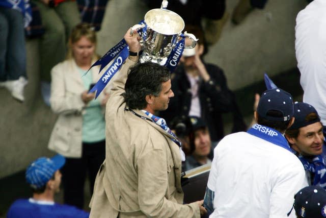 Jose Mourinho holds the League Cup trophy aloft