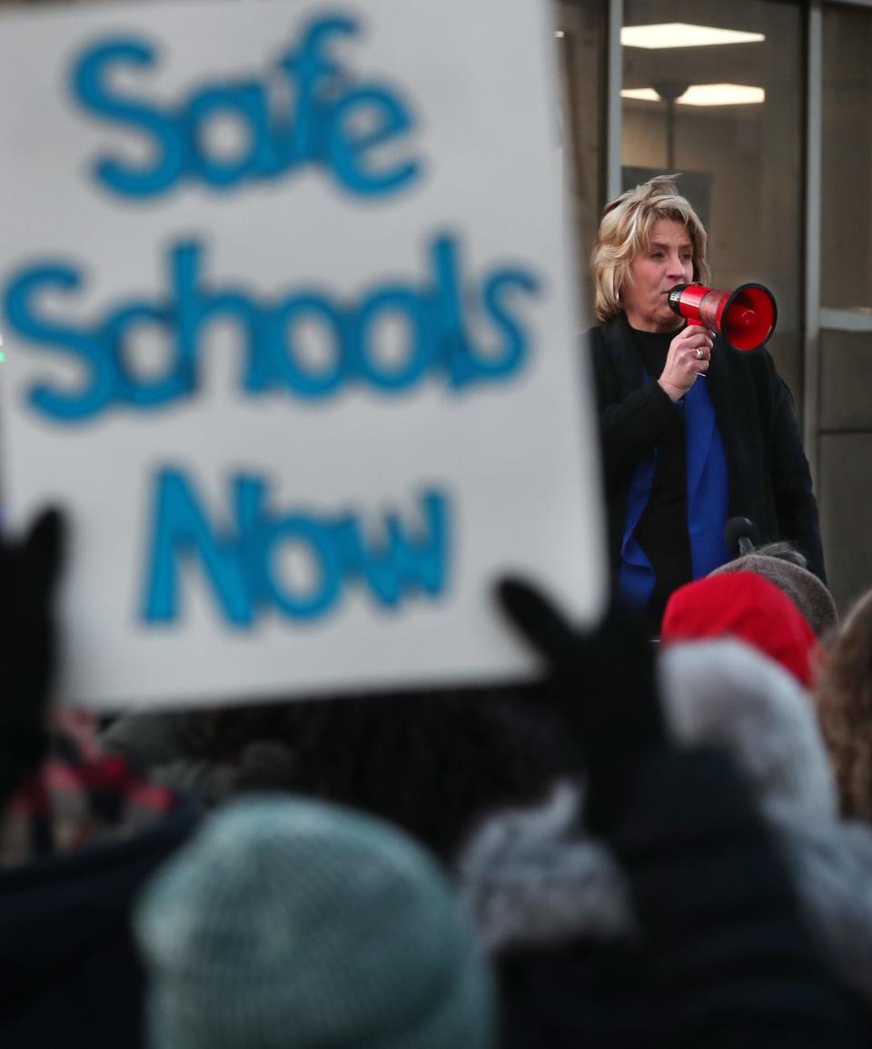 A supporter holds a sign as Akron Education Association President Pat Shipe addresses members and supporters of the teachers union gathered outside the Akron Public Schools administration building last year before a school board meeting.