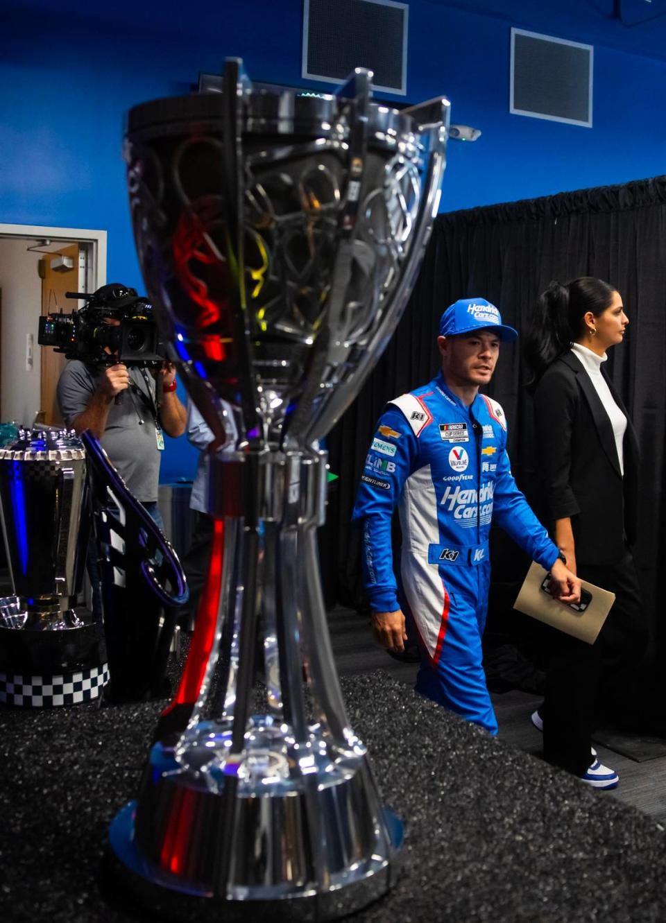 Nov 2, 2023; Avondale, Arizona, USA; NASCAR driver Kyle Larson walks past the Bill France Cup NASCAR Cup Series championship trophy during Championship Media Day at Phoenix Raceway. Mark J. Rebilas/Mark J. Rebilas-USA TODAY Sports