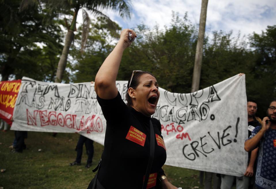 A teacher shouts slogans against the World Cup during a protest outside a hotel where the Brazilian national soccer team has gathered, in Rio de Janeiro May 26, 2014. The Brazilian national soccer team will hold their first training session today. REUTERS/Pilar Olivares (BRAZIL - Tags: SPORT SOCCER WORLD CUP CIVIL UNREST EDUCATION)