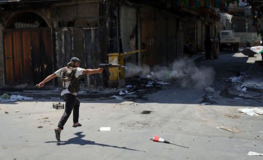 A Syrian rebel from the Free Syrian Army fires his rifle down a street towards government snipers in the Bab Al-Nasr district of the northern restive city of Aleppo