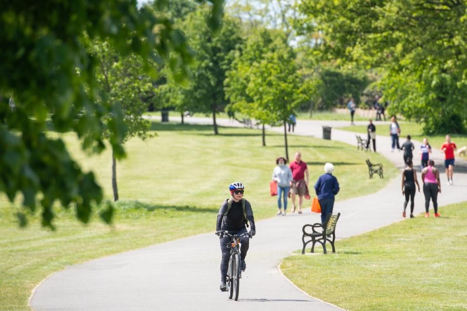 People walk and exercise in the sun in Brockwell Park (Dominic Lipinski/PA)