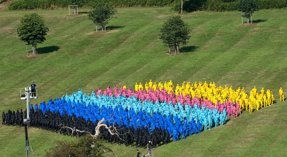 Members of the public take part in a naked installation for Tunick (left in tower) at the Big Chill festival near Ledbury in Herefordshire on August 8, 2010. Those involved were painted in body paints and shot from above to create patterns and designs for the Tunick's photographs.