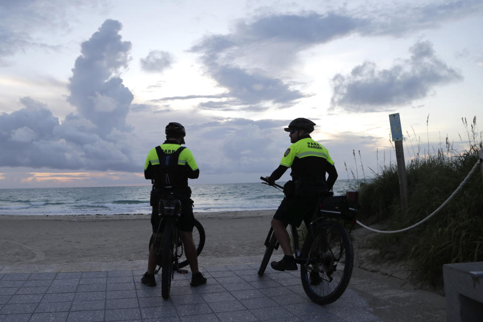 Park rangers look out from South Pointe Park, Saturday, Aug. 31, 2019, in Miami Beach, Fla. Forecasters say Hurricane Dorian will threaten the Florida peninsula late Monday or early Tuesday. (AP Photo/Lynne Sladky)