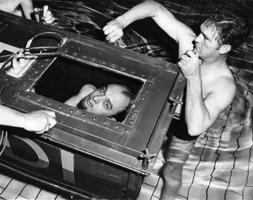 The Amazing Randi, professional escapologist, peering out from a sealed underwater coffin in West Ham Municipal Baths, London, 1958 - Ron Burton/Getty