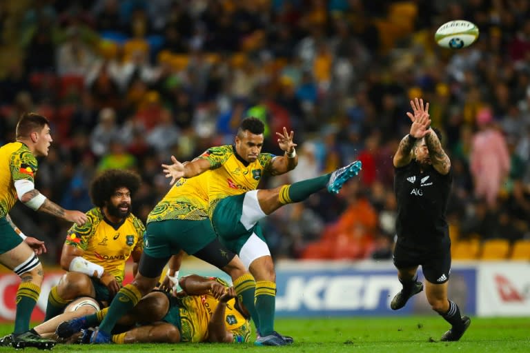 Will Genia of Australia's Wallabies (front L) kicks ahead as Rieko Ioane of New Zealand's All Blacks attempts to charge down during their match in Brisbane on October 21, 2017