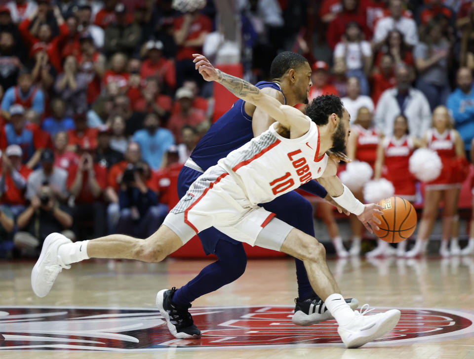 New Mexico guard Jaelen House (10) steals the ball from Nevada guard Hunter McIntosh, top, during the first half of an NCAA college basketball game, Sunday, Jan. 28, 2024, in Albuquerque, N.M. (AP Photo/Eric Draper)