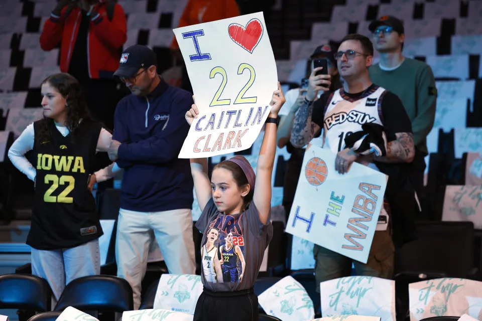 Fans hold up signs for Indiana Fever's Caitlin Clark before the start of a WNBA basketball game against the New York Liberty, Saturday, May 18, 2024, in New York. (AP Photo/Noah K. Murray)