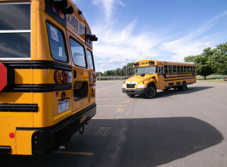 A potential new bus driver behind the wheel of a Livingston Educational Service Agency bus navigates the parking lot of Howell High School with two new Howell Public Schools buses during a 'try-it-out' bus driver enlistment event Thursday, July 28, 2022.