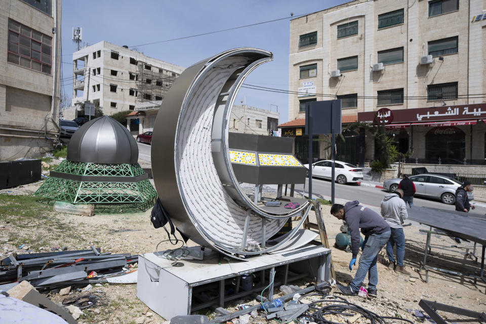 Palestinian labors work on an Islamic style monument that consists of lantern and a crescent, two symbolic icons of the Islamic holy month of Ramadan, in the West Bank city of Ramallah, Tuesday, March 29, 2022. The monument is built by the municipality of Ramallah to decorate a main square at the center of the city, where it will be illuminated during a mass event to celebrate the upcoming Ramadan. (AP Photo/Nasser Nasser)
