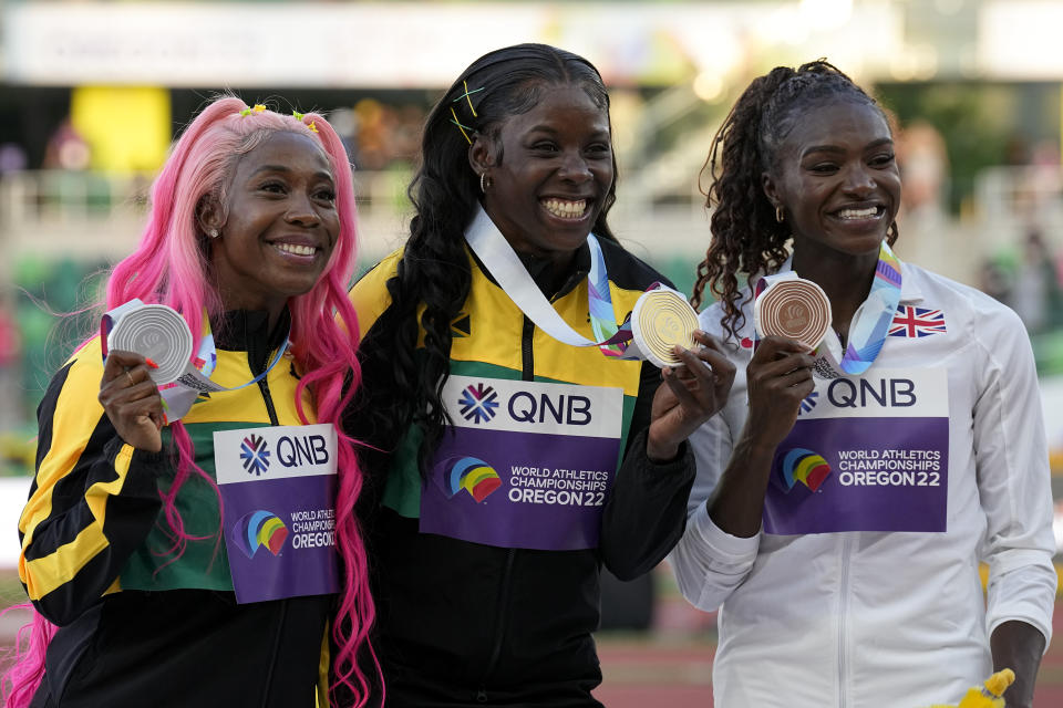 Gold medalist Shericka Jackson, of Jamaica, center, silver medalist Shelly-Ann Fraser-Pryce, of Jamaica, left, and bronze medalist Dina Asher-Smith, of Britain, pose during a medal ceremony for the women's 200-meter run at the World Athletics Championships on Thursday, July 21, 2022, in Eugene, Ore. (AP Photo/Gregory Bull)