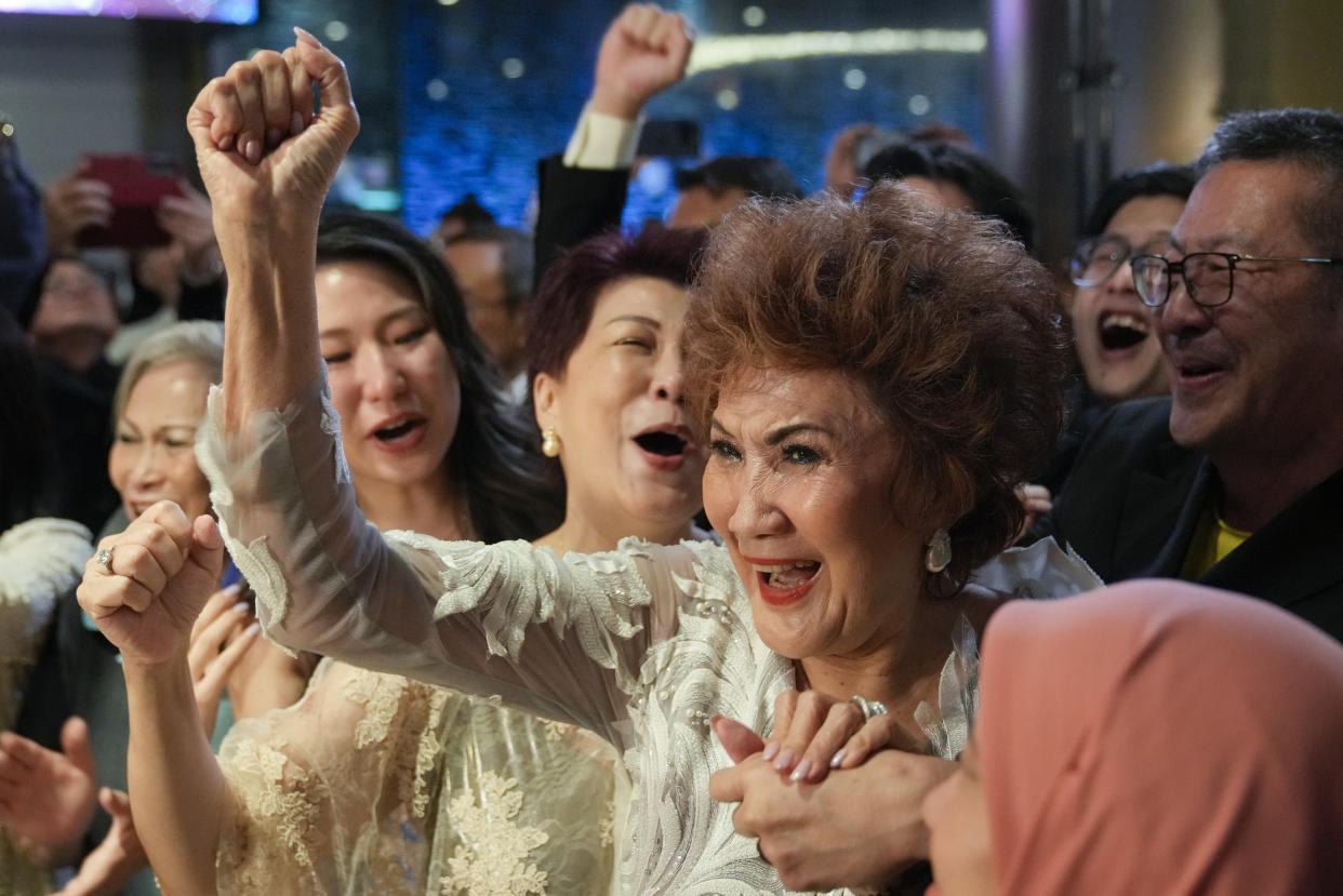 Janet Yeoh, mother of Michelle Yeoh, celebrates after her daughter won in the best actress category during the 95th Academy Awards in Los Angeles, as seen in a live view event at a cinema in Kuala Lumpur, Malaysia, Monday, March 13, 2023. (AP Photo/Vincent Thian)