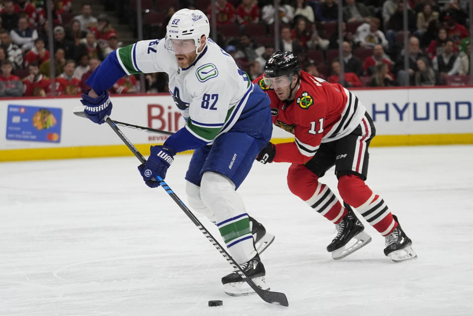 Chicago Blackhawks right wing Taylor Raddysh, right, chases Vancouver Canucks defenseman Ian Cole and the puck during the second period of an NHL hockey game, Tuesday, Feb. 13, 2024, in Chicago. (AP Photo/Erin Hooley)