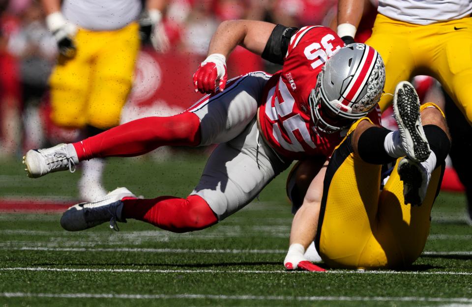 Oct. 22, 2022; Columbus, Ohio, USA; Iowa Hawkeyes tight end Sam LaPorta (84) is brought down by Ohio State Buckeyes linebacker Tommy Eichenberg (35) during the first half of Saturday's game at Ohio Stadium in Columbus. Mandatory Credit: Barbara J. Perenic/Columbus Dispatch