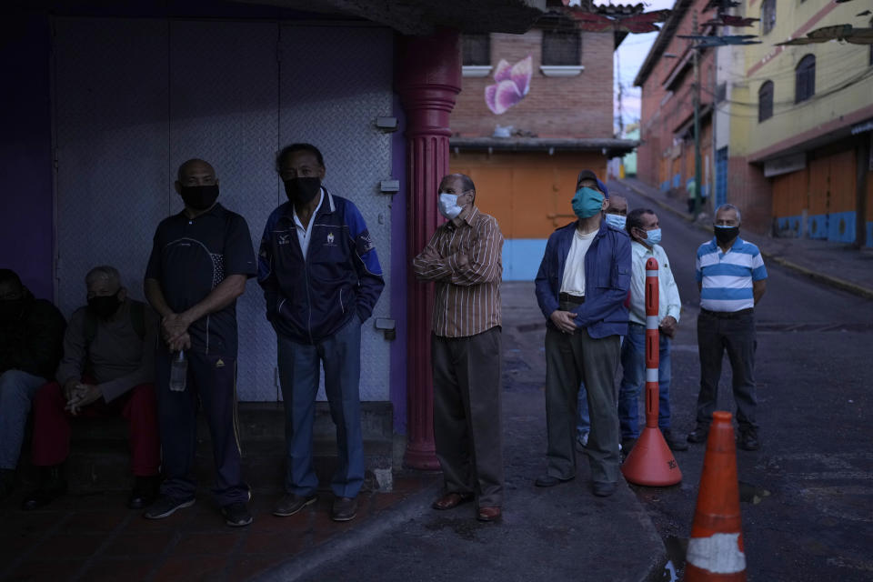 Venezuelans line up to vote during regional elections, at a polling station in Caracas, Venezuela, Sunday, Nov. 21, 2021. Venezuelans go to the polls to elect state governors and other local officials. (AP Photo/Ariana Cubillos)