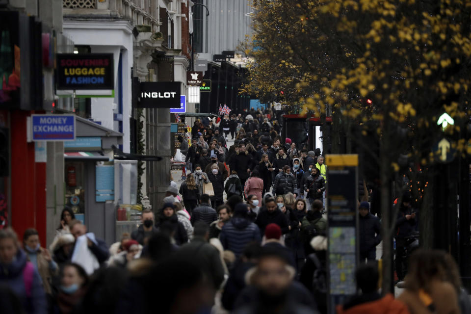 People walk along Oxford Street, where shops are allowed to stay open under the newly placed Tier 3 restrictions for coronavirus in London, Wednesday, Dec. 16, 2020. London and some of its surrounding areas have been placed under Britain's highest level of coronavirus restrictions beginning at 00:01 local time on Wednesday as infections rise rapidly in the capital. Under Tier 3 restrictions, the toughest level in England's three-tier system, people can't socialize indoors, and bars, pubs and restaurants must close except for takeout. (AP Photo/Matt Dunham)
