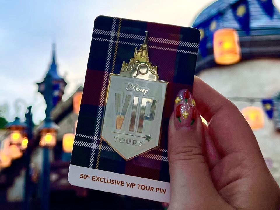 hand holding special disney world vip tour pin