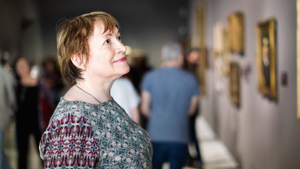 Closeup on attentive pleasant senior woman visiting museum and enjoying arts.