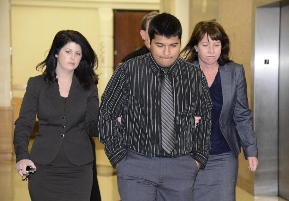 Erick Munoz, center, husband of Marlise Munoz is escorted by attorneys as he walks to 96th District Court Friday, Jan. 24, 2014 in Fort Worth, Texas. A judge has ordered a Texas hospital to remove life support for a pregnant, brain-dead woman. Judge R. H. Wallace Jr. issued the ruling Friday in the case of Marlise Munoz. John Peter Smith Hospital in Fort Worth has been keeping Munoz on life support against her family's wishes. Munoz was 14 weeks pregnant when her husband found her unconscious Nov. 26, possibly due to a blood clot. (AP Photo/Tim Sharp)