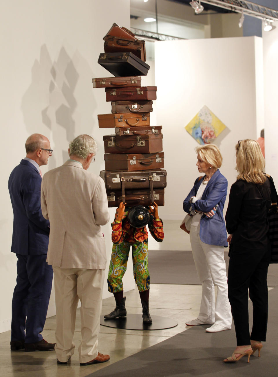 FILE - This Dec. 5, 2012 file photo shows a crowd of people looking at a sculpture titled "Homeless boy," by Yinka Shonibare on display as part of Art Basel Miami Beach in Miami Beach, Fla. The 2013 Art Basel Miami Beach takes place Dec. 5-8. (AP Photo/Wilfredo Lee, File)