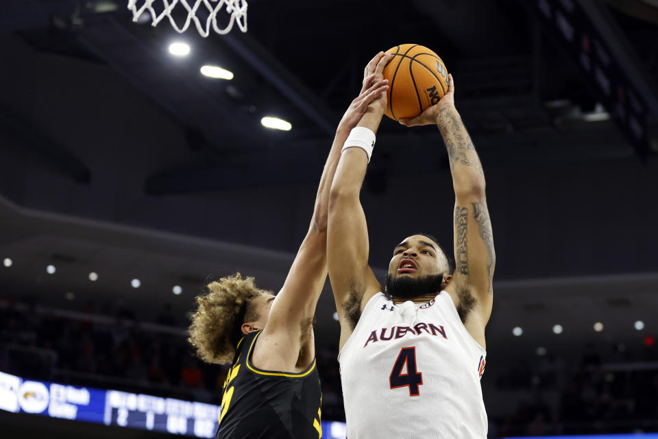 Auburn forward Johni Broome (4) is fouled by Missouri forward Noah Carter as he dunks the ball during the second half of an NCAA college basketball game, Tuesday, Feb. 14, 2023, in Auburn, Ala. (AP Photo/Butch Dill)