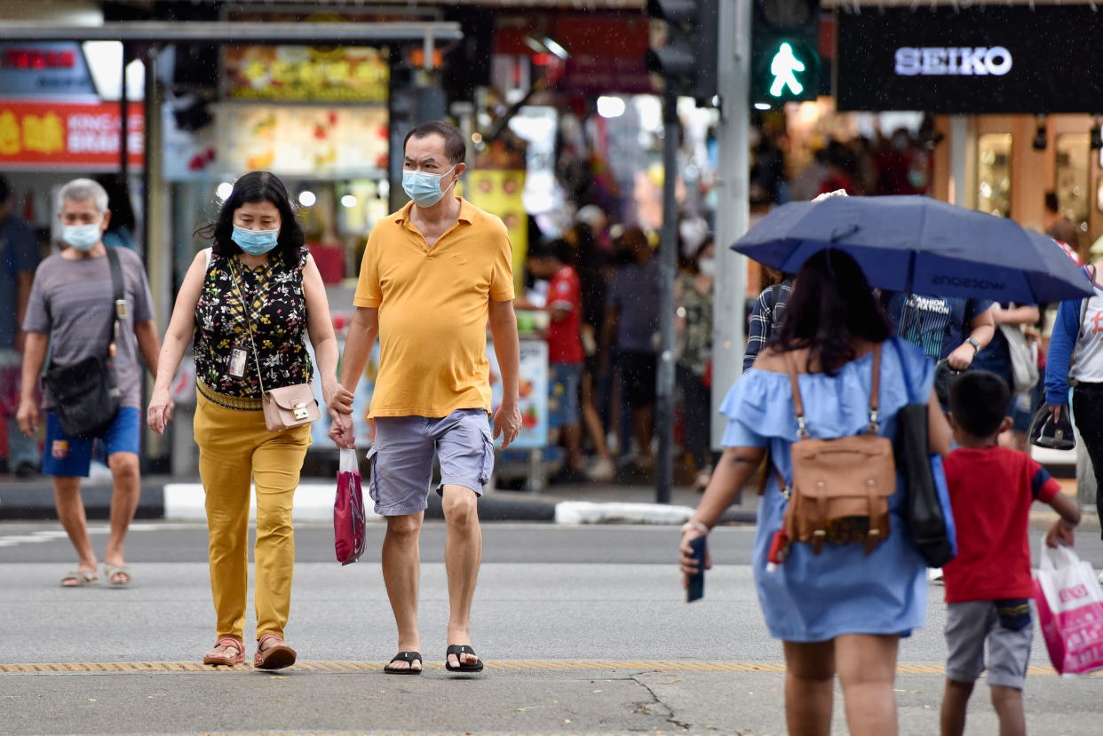 People cross a road, amidst the coronavirus disease (COVID-19) pandemic, in Singapore November 3, 2021. REUTERS/Caroline Chia