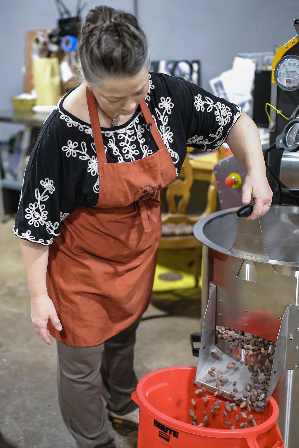 Owner Maura Baker shows off a machine with Colombia Tumaco Cacao inside at Zero Tolerance Coffee and Chocolate in Oklahoma City.