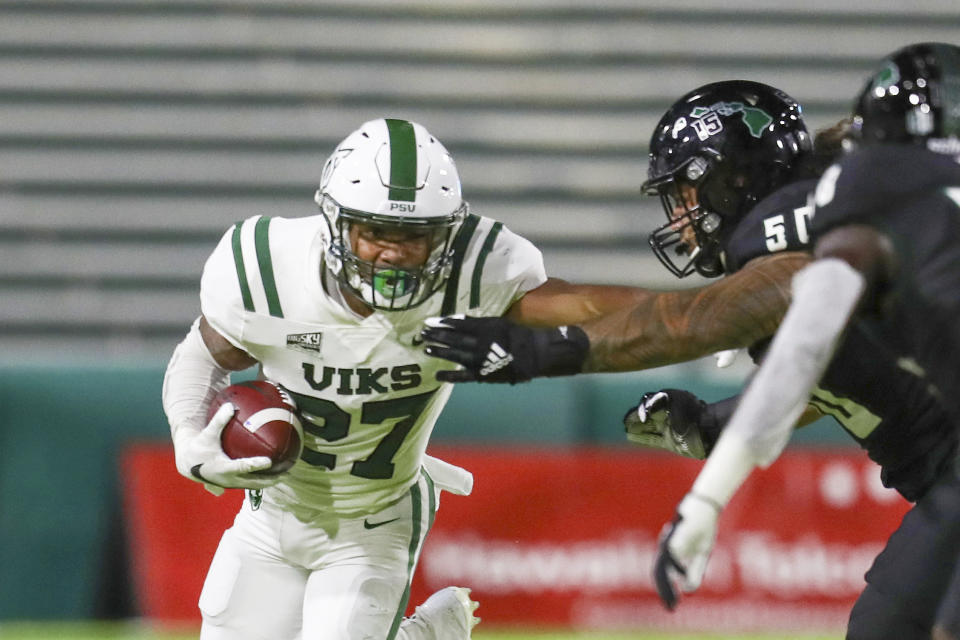 Portland State running back Malik Walker (27) stiff arms Hawaii defensive lineman Justus Tavai (50) as he runs the ball during the first half of an NCAA college football game, Saturday, Sept. 4, 2021, in Honolulu. (AP Photo/Darryl Oumi)