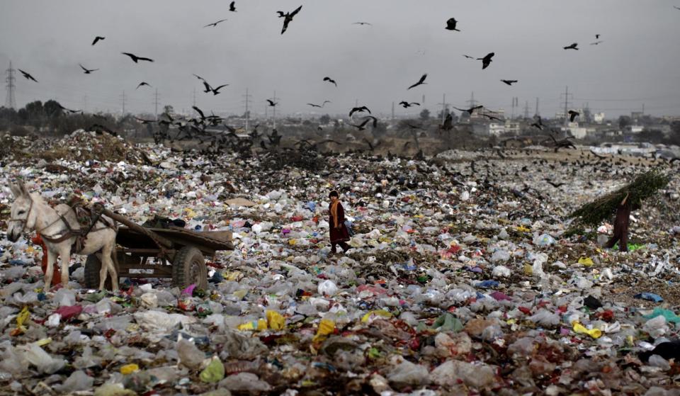 In this Tuesday, Feb. 12, 2013, photo, a Pakistani girl, center, collects useful items from a garbage dump, to be sold after, on the outskirts of Islamabad, Pakistan. Wonder Woman and Supergirl now have a Pakistani counterpart in the pantheon of female superheroes _ one who shows a lot less skin. Meet Burka Avenger: a mild-mannered teacher with secret martial arts skills who uses a flowing black burka to hide her identity as she fights local thugs seeking to shut down the girls' school where she works. Sadly, it's a battle Pakistanis are all too familiar with in the real world.(AP Photo/Muhammed Muheisen)