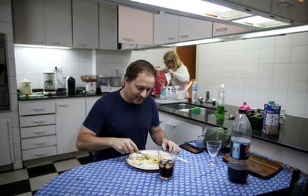 Guillermo Galia eats lunch at his home, in Buenos Aires