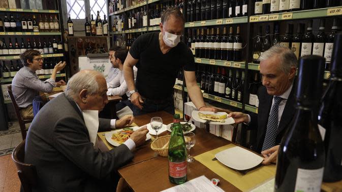 Waiters melayani pelanggan di dalam restoran di pusat kota Roma, Italia. (AP Photo/Gregorio Borgia)