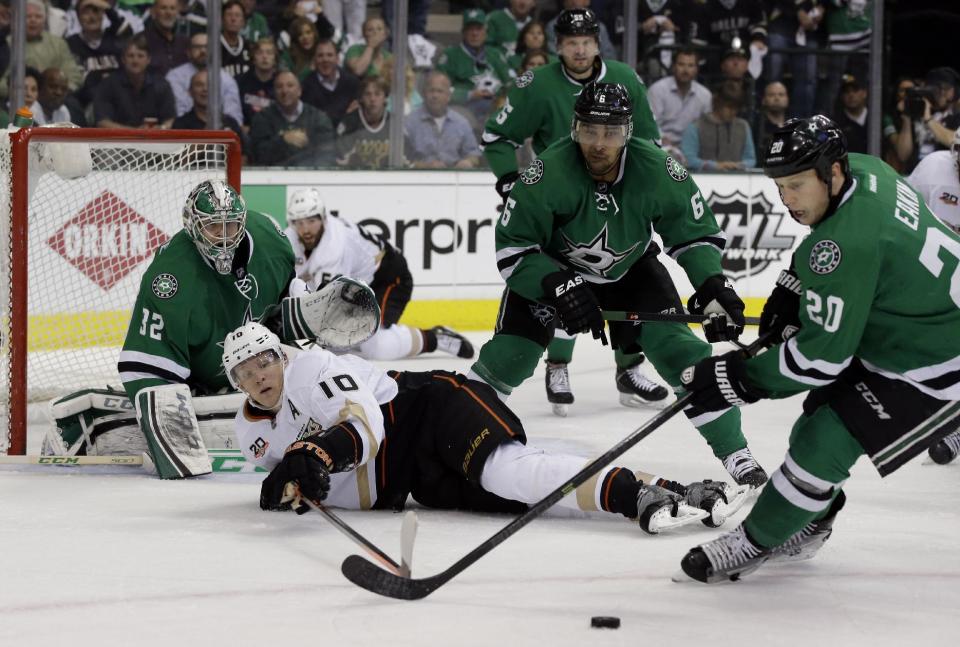 Anaheim Ducks' Corey Perry (10) has the puck stripped by the combined effort of Dallas Stars' Trevor Daley (6) and Cody Eakin (20) as goalie Kari Lehtonen (32), of Finland, watches in the second period of Game 4 of a first-round NHL hockey Stanley Cup playoff series, Wednesday, April 23, 2014, in Dallas. (AP Photo/Tony Gutierrez)