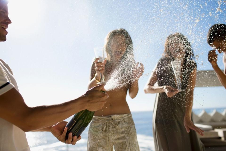 Lottery winners celebrate by showering in champagne on friends. Source: Getty Images