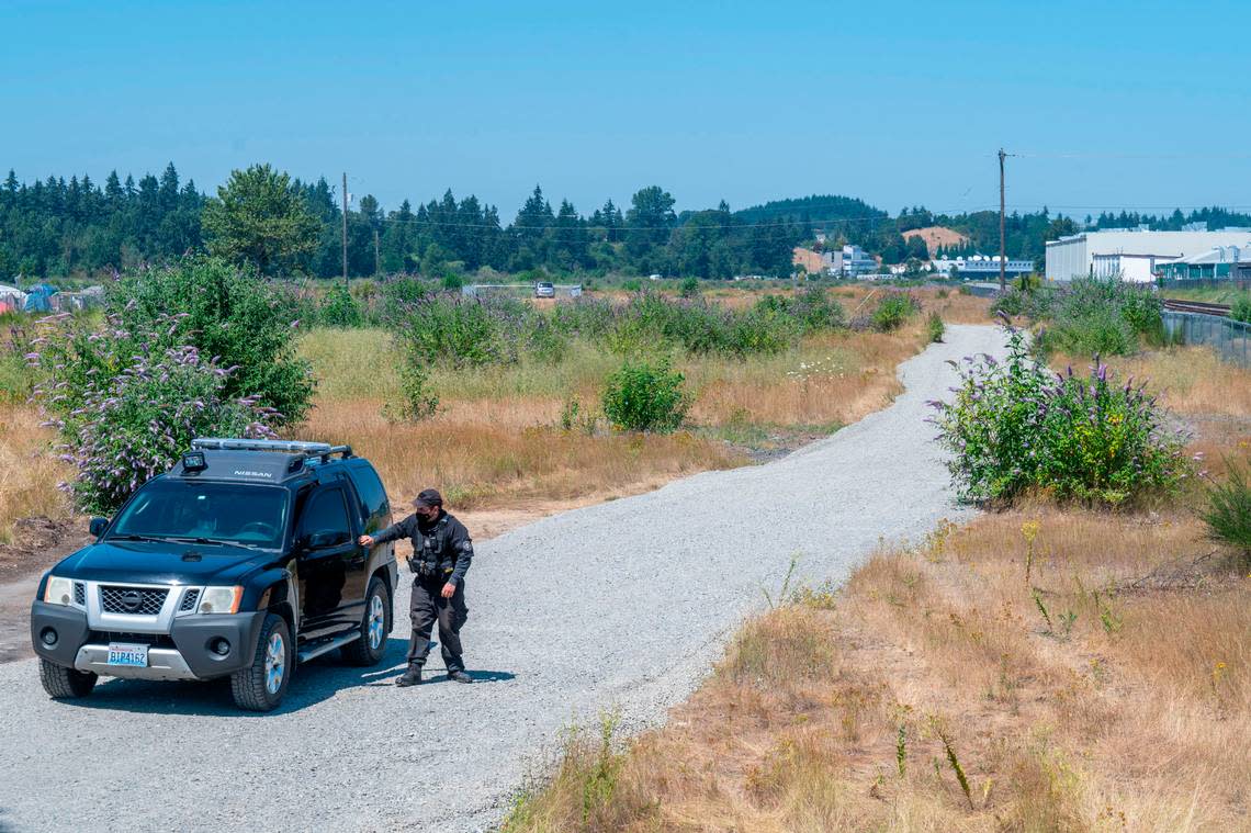 A security detail checks out the fence area at the proposed Bridge Industrial site Wednesday, July 27, 2022, in Tacoma, Wash. Bridge Industrial plans to redevelop about 150 acres of the former BNSF site in South Tacoma.