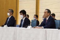 ADDS NAMES OF PARTICIPANTS - Japanese Prime Minister Yoshihide Suga, right, with Dr. Shigeru Omi, left, who heads the government taskforce and Norihisa Tamura, center, Minister of Health, Labor and Welfare, attends the government task force meeting for the COVID-19 measures at the prime minister's office Friday, April 9, 2021, in Tokyo. Japan announced Friday that it will raise the coronavirus alert level in Tokyo to allow tougher measures to curb the rapid spread of a more contagious variant ahead of the Summer Olympics. (AP Photo/Eugene Hoshiko, Pool)