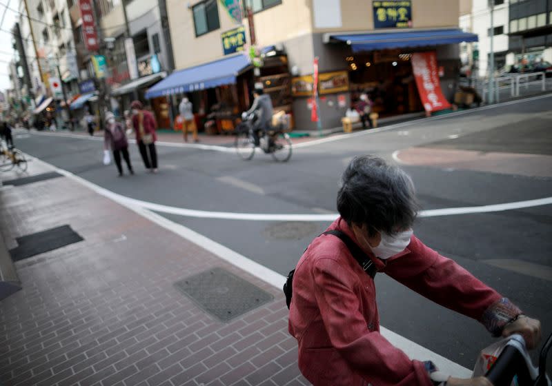 Elderly people wearing protective face masks walk on the street after the government announced state of emergency at Sugamo district in Tokyo, Japan