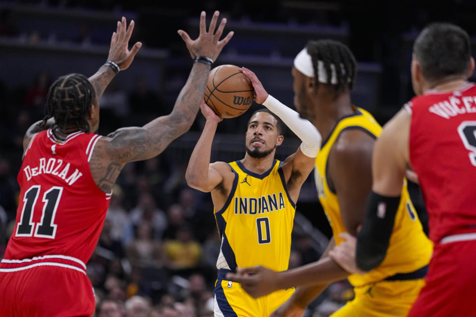 Indiana Pacers guard Tyrese Haliburton (0) shoots over Chicago Bulls forward DeMar DeRozan (11) during the first half of an NBA basketball game in Indianapolis, Monday, Oct. 30, 2023. (AP Photo/Michael Conroy)