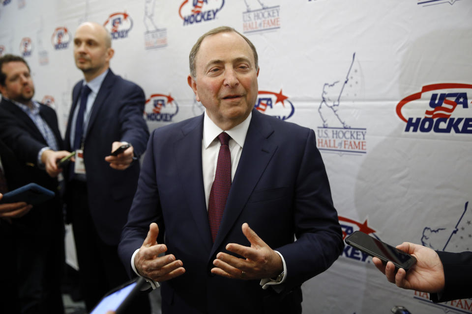 FILE - NHL Commissioner Gary Bettman speaks with members of the media before being inducted into the U.S. Hockey Hall of Fame in Washington, in this Thursday, Dec. 12, 2019, file photo. Like the NBA, the NHL is going forward with a season without a bubble. Commissioner Gary Bettman, Players' Association executive director Don Fehr and other top officials explain how hockey got to this point with a CBA that may have only staved off headaches and playing in mostly empty home arenas to start. (AP Photo/Patrick Semansky, File)