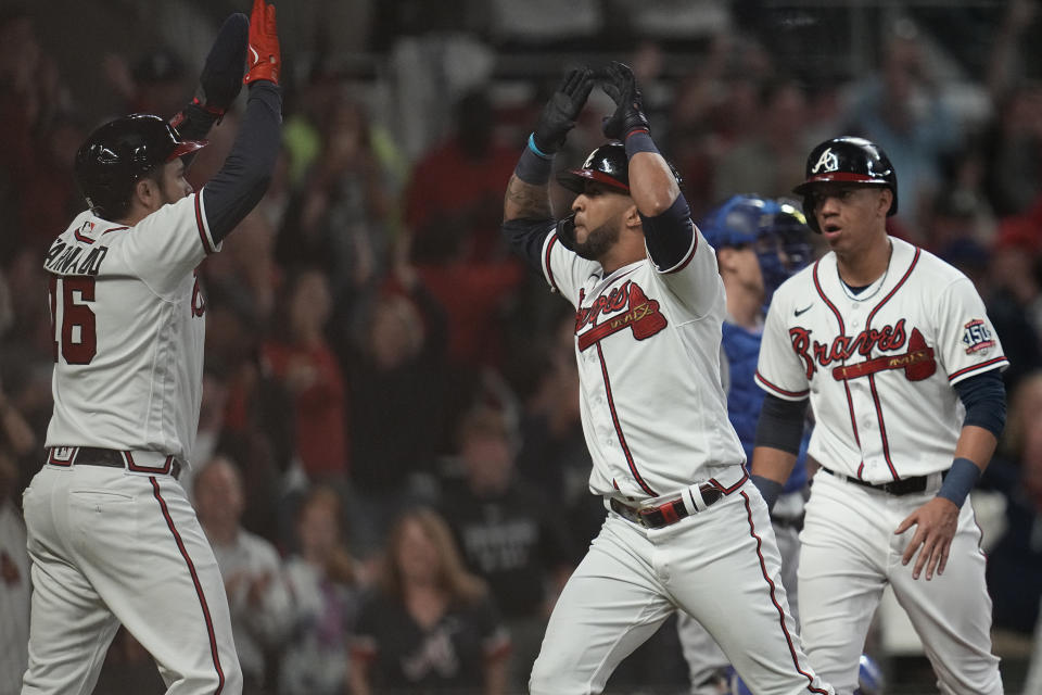 Atlanta Braves' Eddie Rosario, center, celebrates after hitting a three run home run during the fourth inning in Game 6 of baseball's National League Championship Series against the Los Angeles Dodgers Saturday, Oct. 23, 2021, in Atlanta.(AP Photo/Ashley Landis)