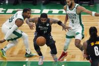 Brooklyn Nets' Kyrie Irving (11) loses control of the ball against Boston Celtics' Marcus Smart (36) and Jayson Tatum (0) during the first half of an NBA basketball game, Friday, Dec. 25, 2020, in Boston. (AP Photo/Michael Dwyer)