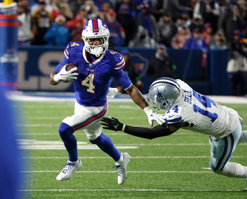 Buffalo Bills running back James Cook (4) breaks a tackle by Dallas Cowboys safety Markquese Bell (14). Cook rushed for 179 yards in 31-10 Bills win.