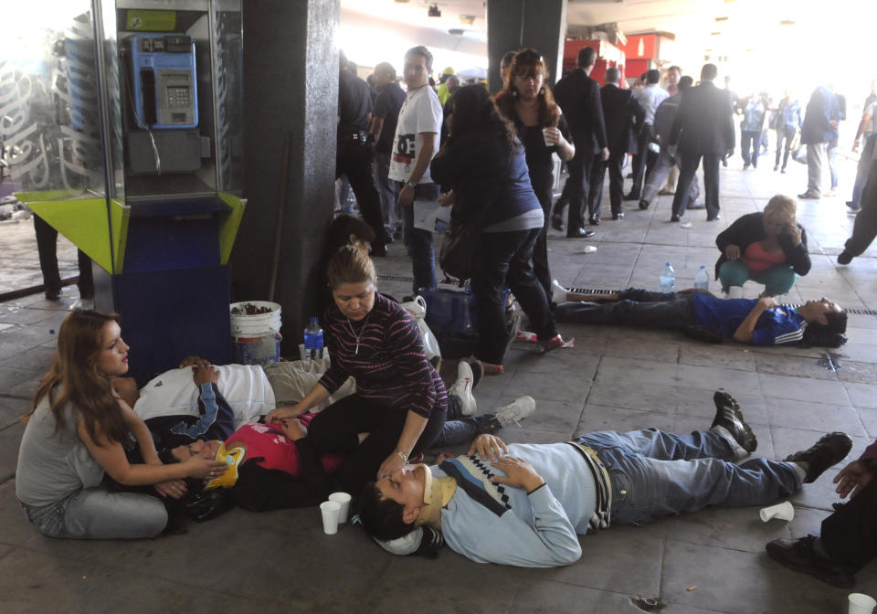 Injured passengers from a commuter train wait to be carried away after a collision in Buenos Aires, Argentina, Wednesday Feb. 22, 2012. A packed train slammed into the end of the line in Buenos Aires' busy Once station Wednesday, killing dozens and injuring hundreds, according to police. (AP Photo/Leonardo Zavattaro,Telam)