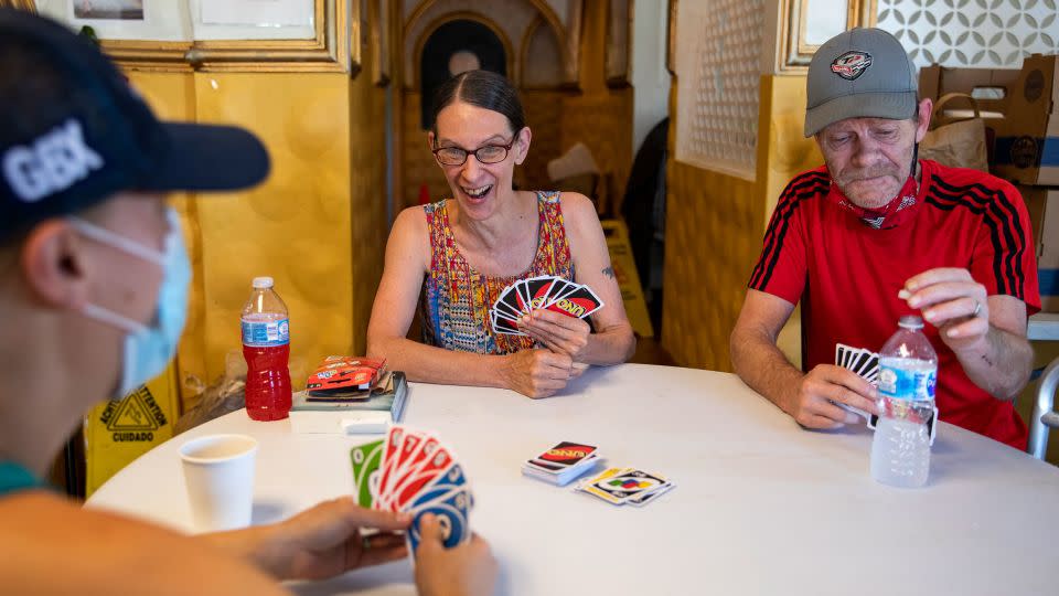 Morgan Coder, left, plays Uno with Kathleen Stoughton, 64, center, and Kathleen's husband Kim, 61, at a cooling center in Portland, Oregon in 2021. - Alisha Jucevic/For The Washington Post/Getty Images